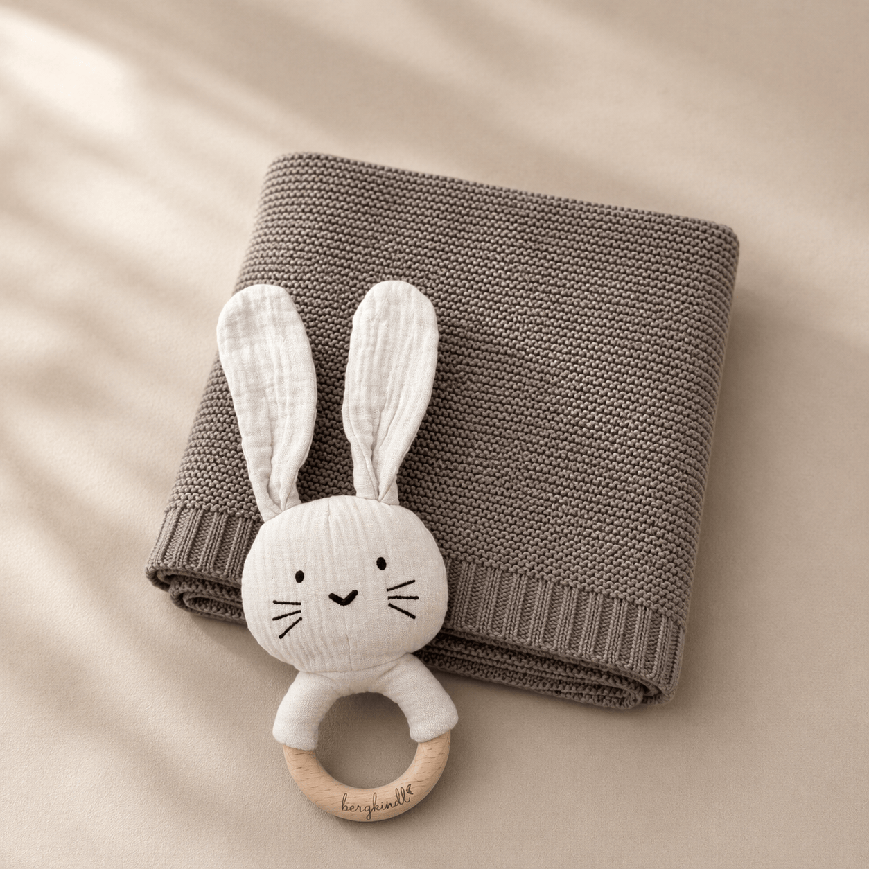 Geschenk zur Geburt – Babydecke in greige mit Hasenrassel
