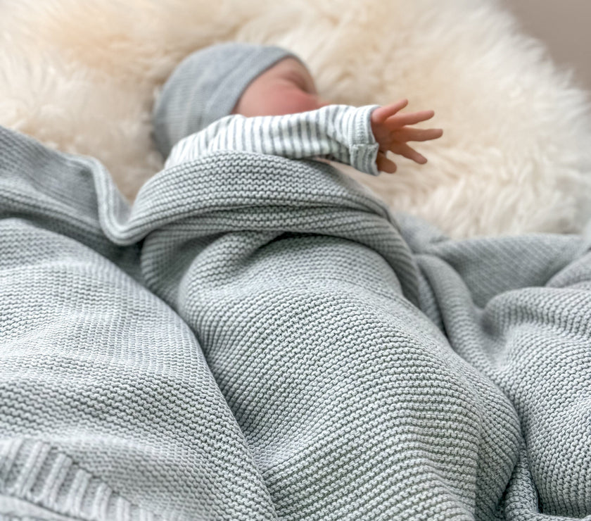 Babydecke grau mit Baby eingehüllt
